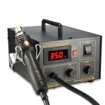 A close-up photo of a silver INGCO PTEH-Atten-AT850B soldering workstation with a digital display. The station has a hot air gun with a pistol grip and a soldering iron with a black handle, both with replaceable tips. There is a sponge for cleaning the soldering iron tip, and a metal stand for holding the soldering iron and hot air gun.